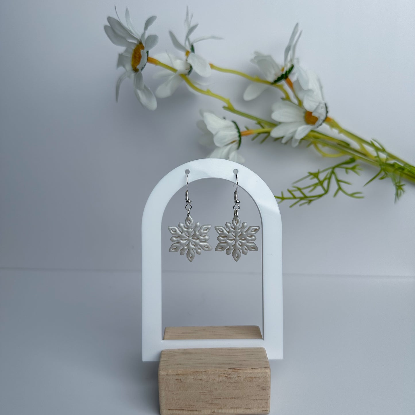 Silver snowflake earrings by Purely Clayful, featuring intricate designs, dangling style, and lightweight material.