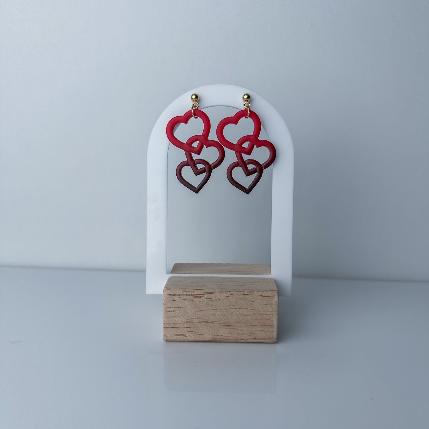 Red interlocking heart dangle earrings with gold accents by Purely Clayful