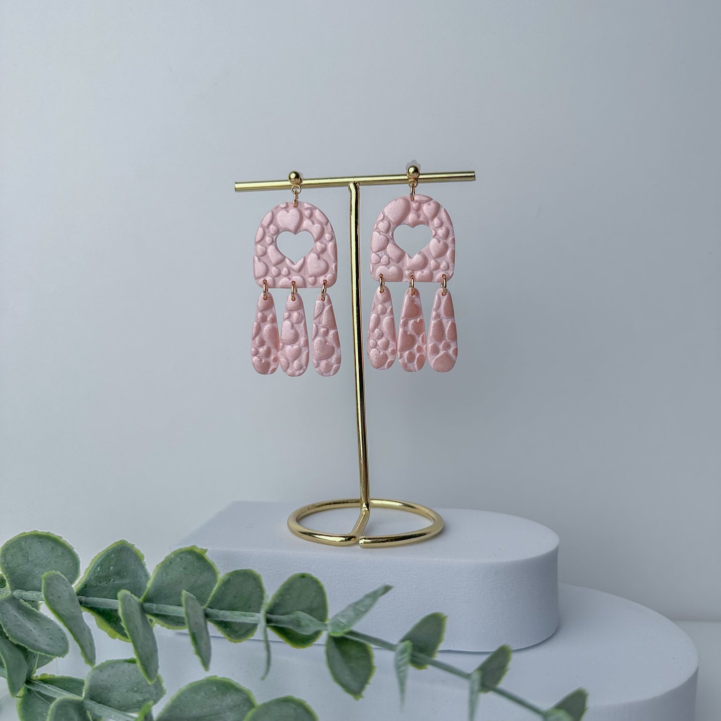 Textured pink heart cutout dangle earrings by Purely Clayful with three drop elements.