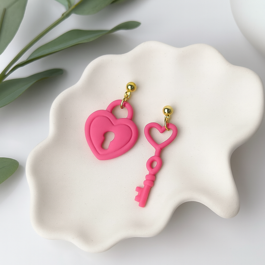 Handcrafted pink heart lock and key earrings by Purely Clayful, featuring gold accents and a bold statement design.