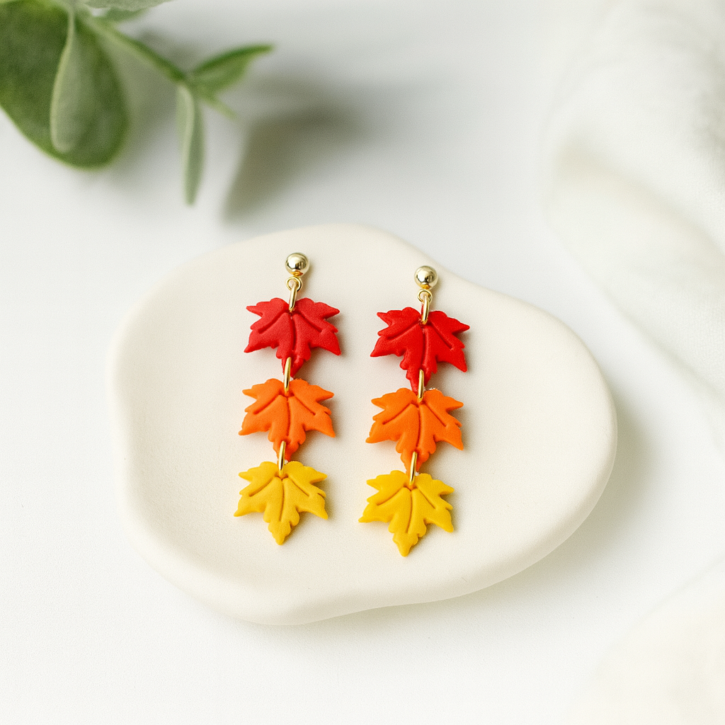 Colorful leaf-shaped earrings on a white stone with green leaves in the background